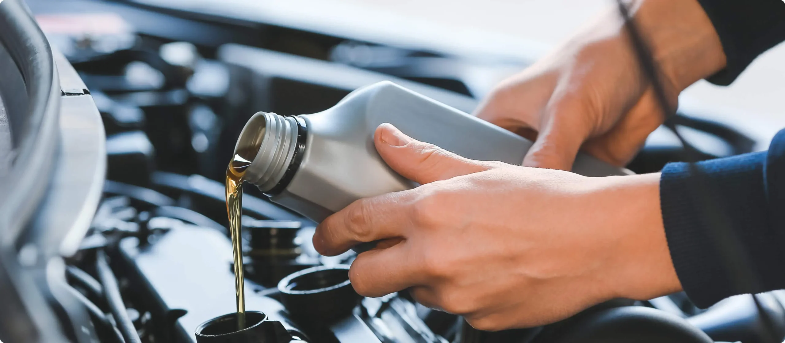 Close-up of motor oil being poured into a car engine, featuring Sinopec branding, representing clean and professional industrial web design for the automotive sector.